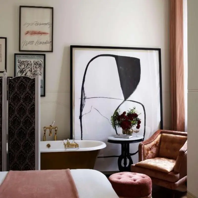 Guest room at Nomad London with freestanding bath and large abstract artwork