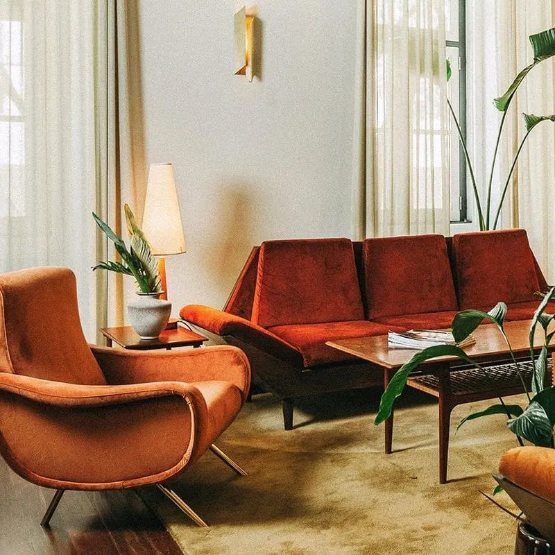 Guest lounge at The Vintage Hotel Príncipe Real Lisbon with mid-century orange armchairs