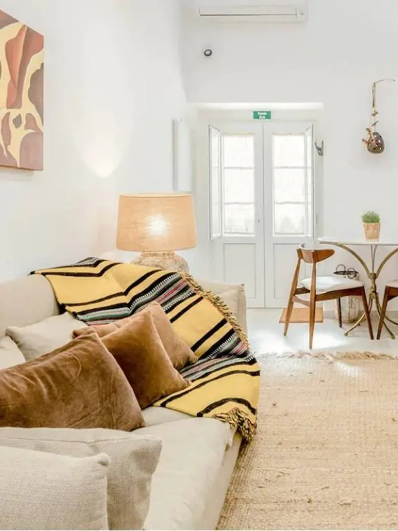 Bright loft living area with sofa, dining nook, and whitewashed walls