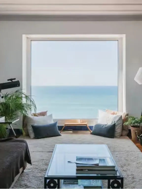 Living room with panoramic ocean-facing window and seating nook