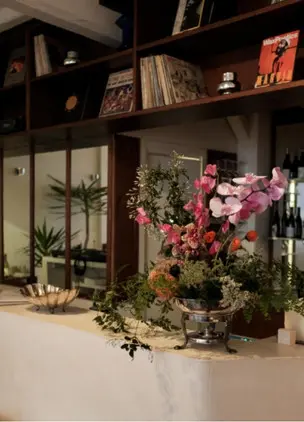 Floral display and record-lined interior at 33 Giri, one of Rome’s most atmospheric places to eat and drink
