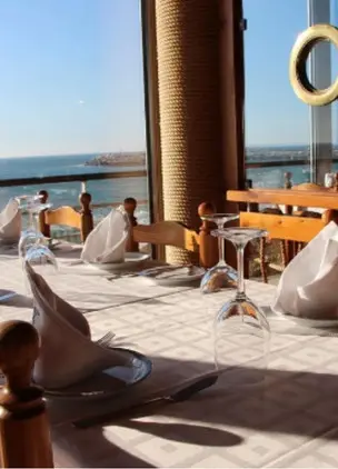 Restaurant table by panoramic seaside windows overlooking the water