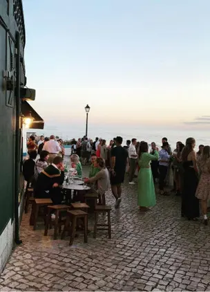 Outdoor cobblestone terrace gathering at sunset overlooking the sea