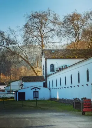 Historic winery building exterior surrounded by trees and open grounds