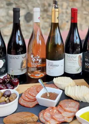 Selection of wine bottles served with charcuterie, cheese, and bread for tasting