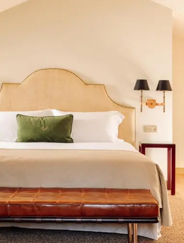 Guest room at Hotel das Amoreiras Lisbon with rattan headboard and leather bench