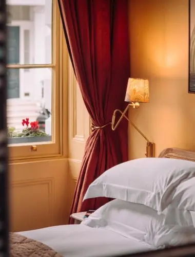 Guest room at The Portobello Hotel Notting Hill with red drapes and antique furniture