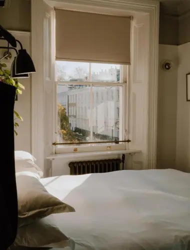 Guest room at The Pilgrm quiet hotel in London with white linen and sash windows
