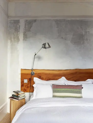 Guest room at The Culpeper London with timber headboard and white linen