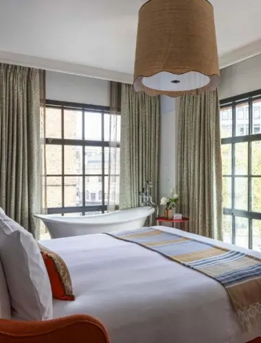 Guest room at Virgin Hotels London Shoreditch with freestanding bath