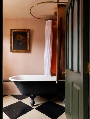 Freestanding bath at Hazlitt's hotel London with black and white tiled floor