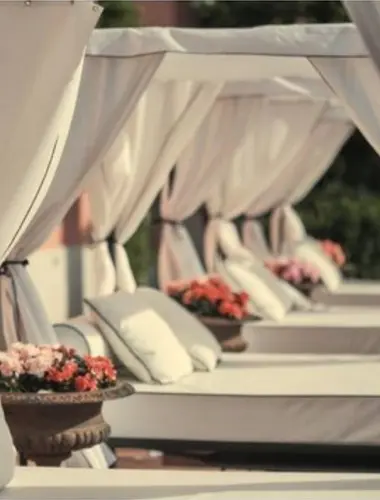 Canopied sun loungers at Torel Palace Lisbon hotel with pool in Lisbon