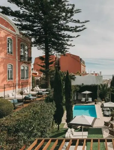 Garden pool at Torel Palace Lisbon with pine trees and city views