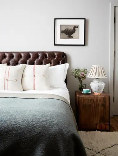 Guest room at Artist Residence London with leather headboard and grey linen