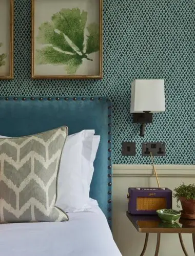 Guest room at Room Mate Lime Tree Belgravia with teal wallpaper and linen pillows