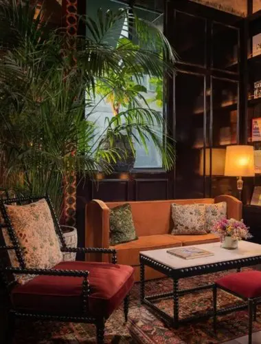 Lobby at The Ivens Lisbon with tropical plants and velvet armchairs