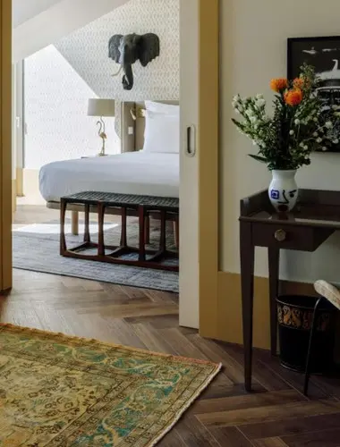 Guest room at The Ivens Chiado Lisbon with terracotta rug and elephant wall sculpture