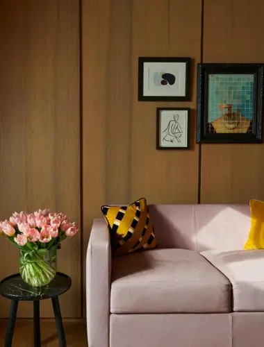 Oak-panelled guest room at Hotel Cafe Royal London with pink armchair and framed artwork