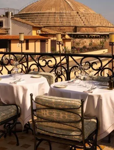 Rooftop dining terrace at Orient Express La Minerva with views toward the Pantheon and Rome’s domes
