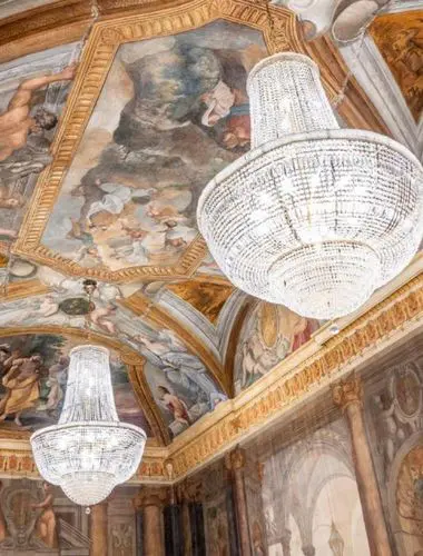 Frescoed ceiling and crystal chandeliers inside Palazzo Roma’s restored historic interiors